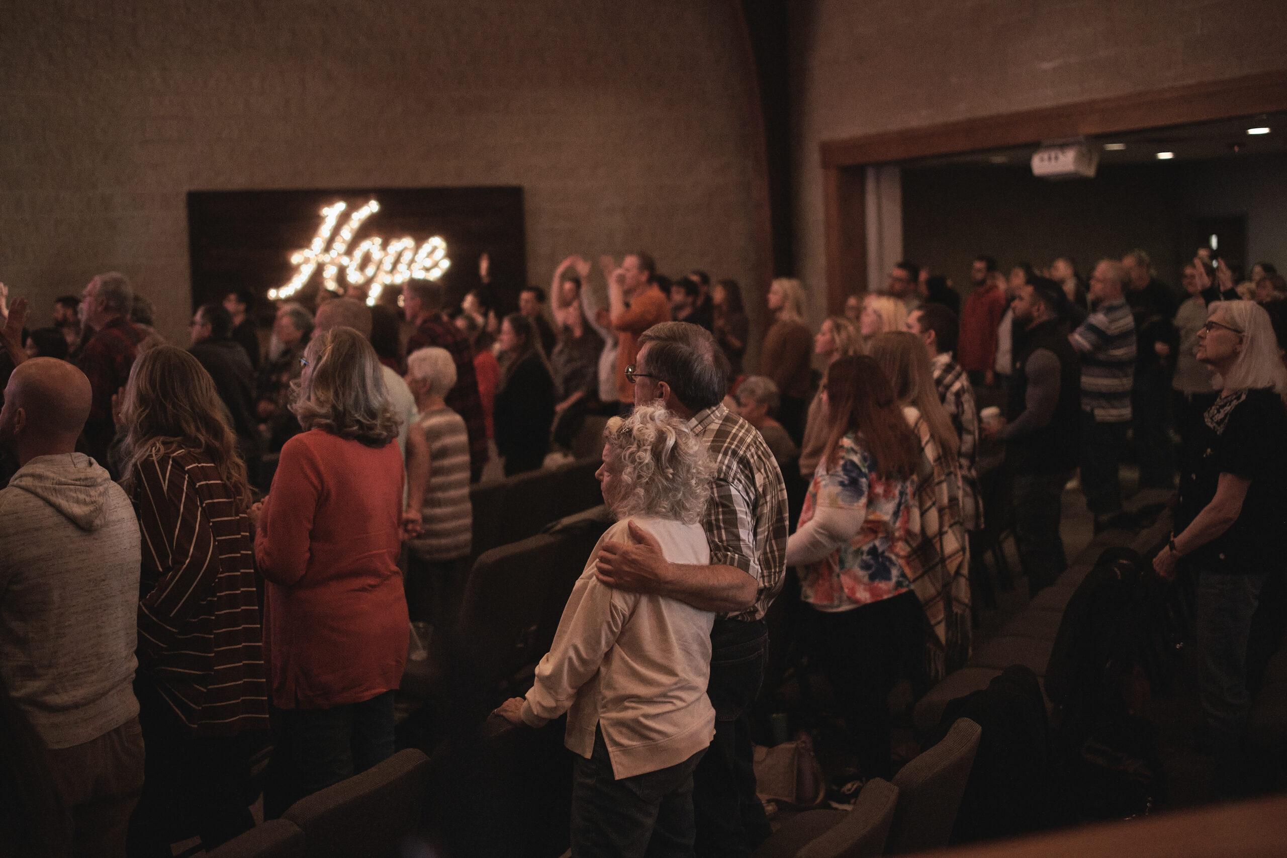 worship service man with arm around his wife